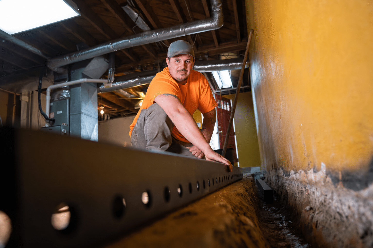 Worker Installing Interior Drain Tile